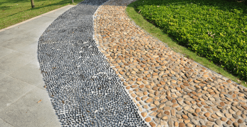 A path with three different types of aggregate leading to a building in the distance